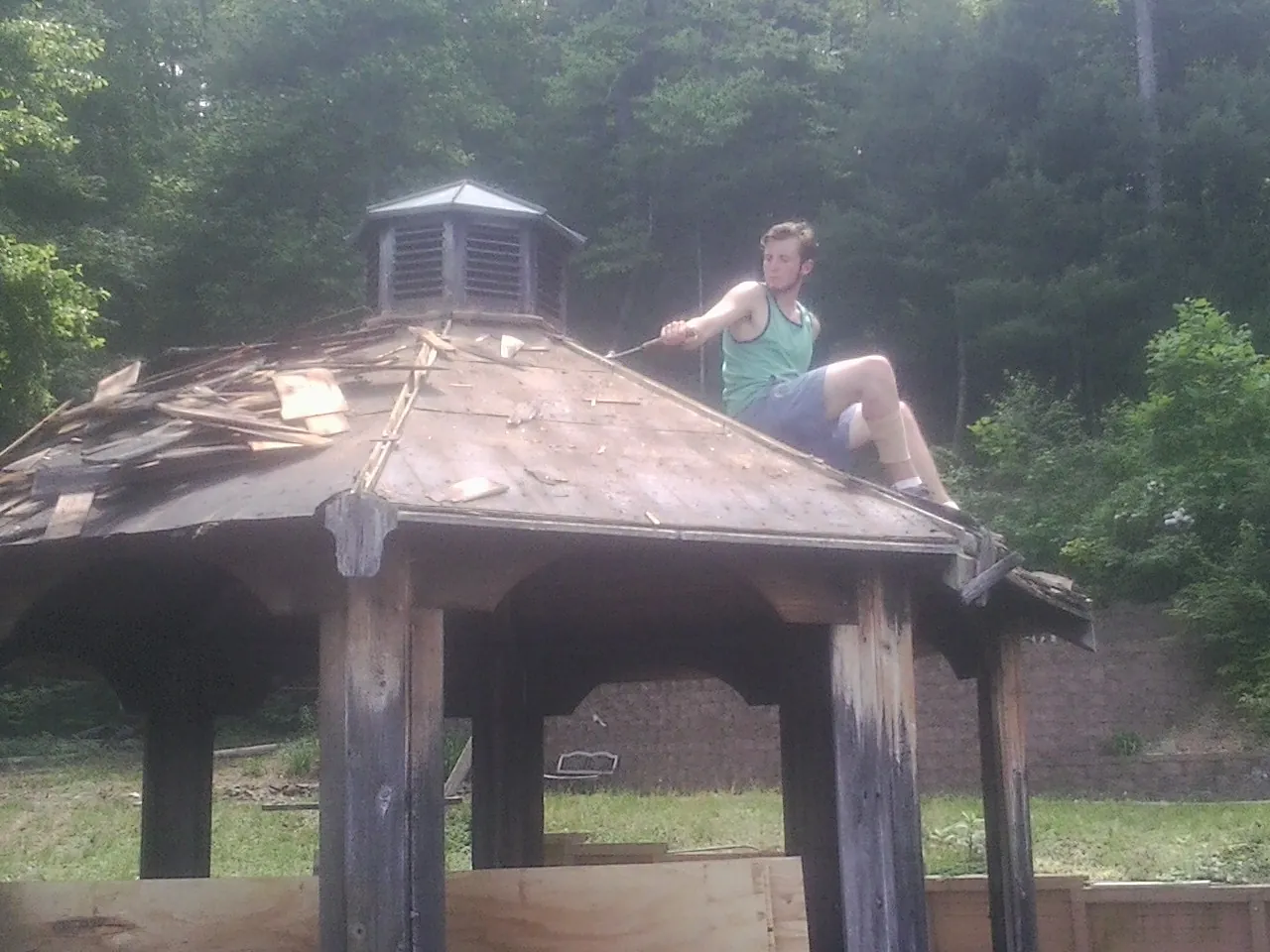 Tearing the old roof off a wooden gazebo before new shakes in Lake Panasoffkee